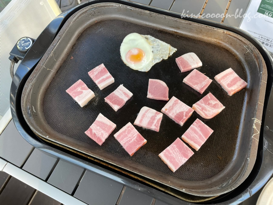 ウフフヴィレッジの朝食のベーコンと卵をホットプレートで焼いているところ